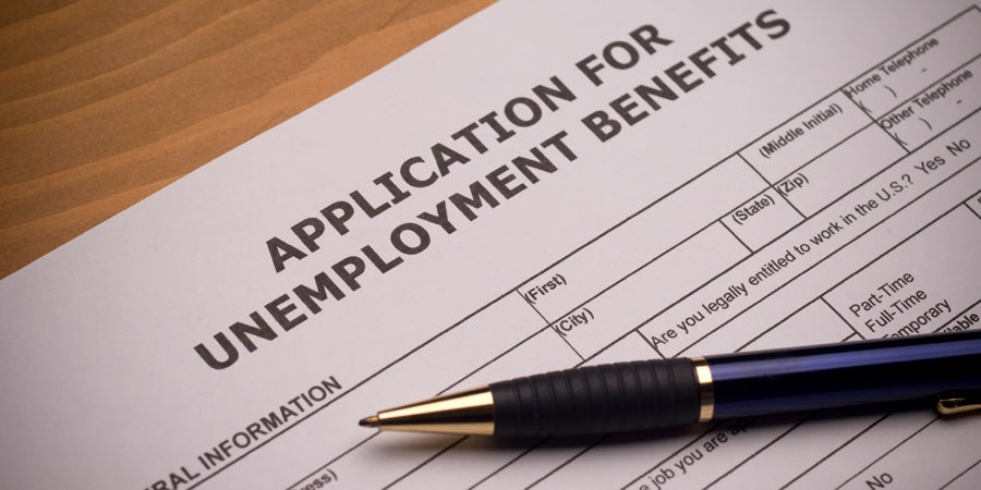 Close up image of a blank application for unemployment benefits form with a pen