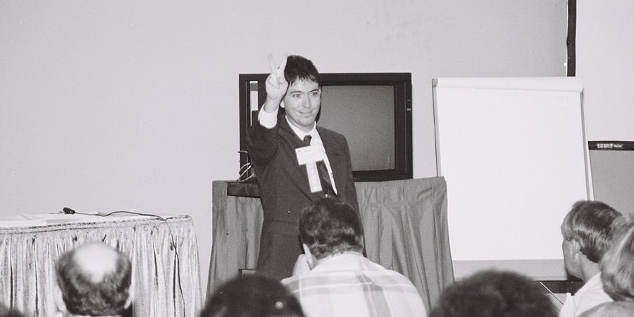 Man holding up two fingers in business meeting