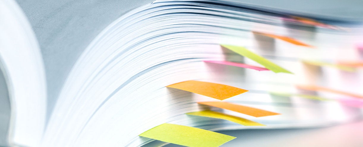 A thick book with many post-its bookmarking important pages.