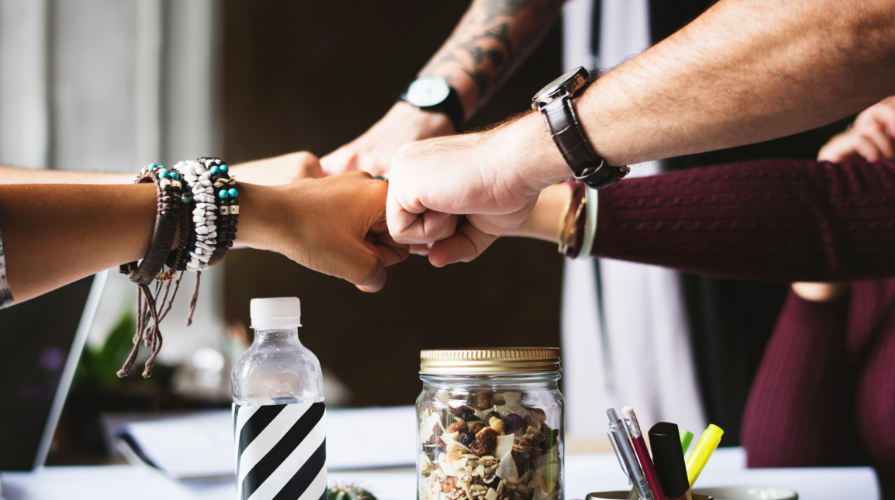 photo of five fists coming together for a team fist bump